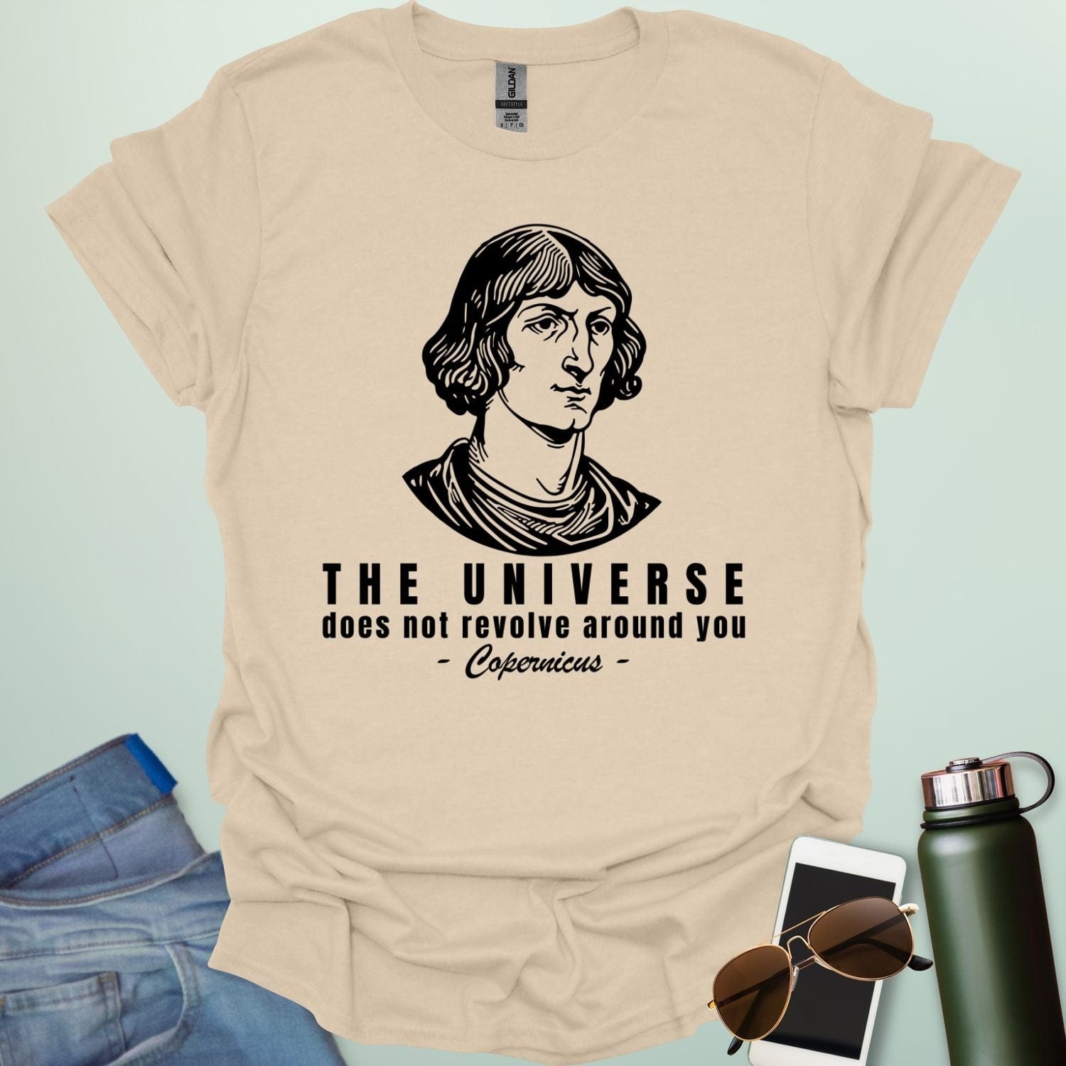A tan shirt with a sketch of Copernicus with the text 'The Universe Does Not Revolve Around You' in a bold font.
