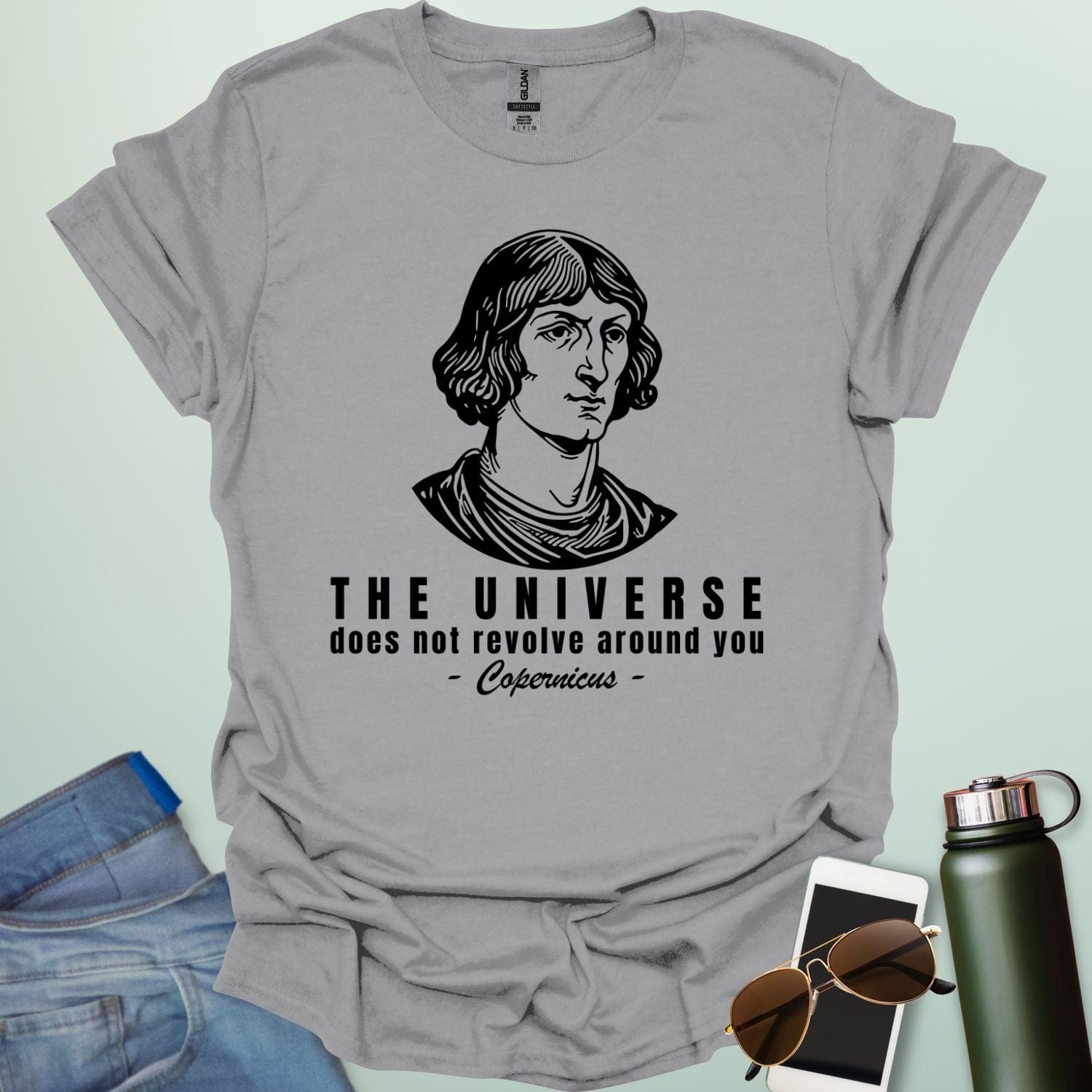 A sport grey shirt with a sketch of Copernicus with the text 'The Universe Does Not Revolve Around You' in a bold font.