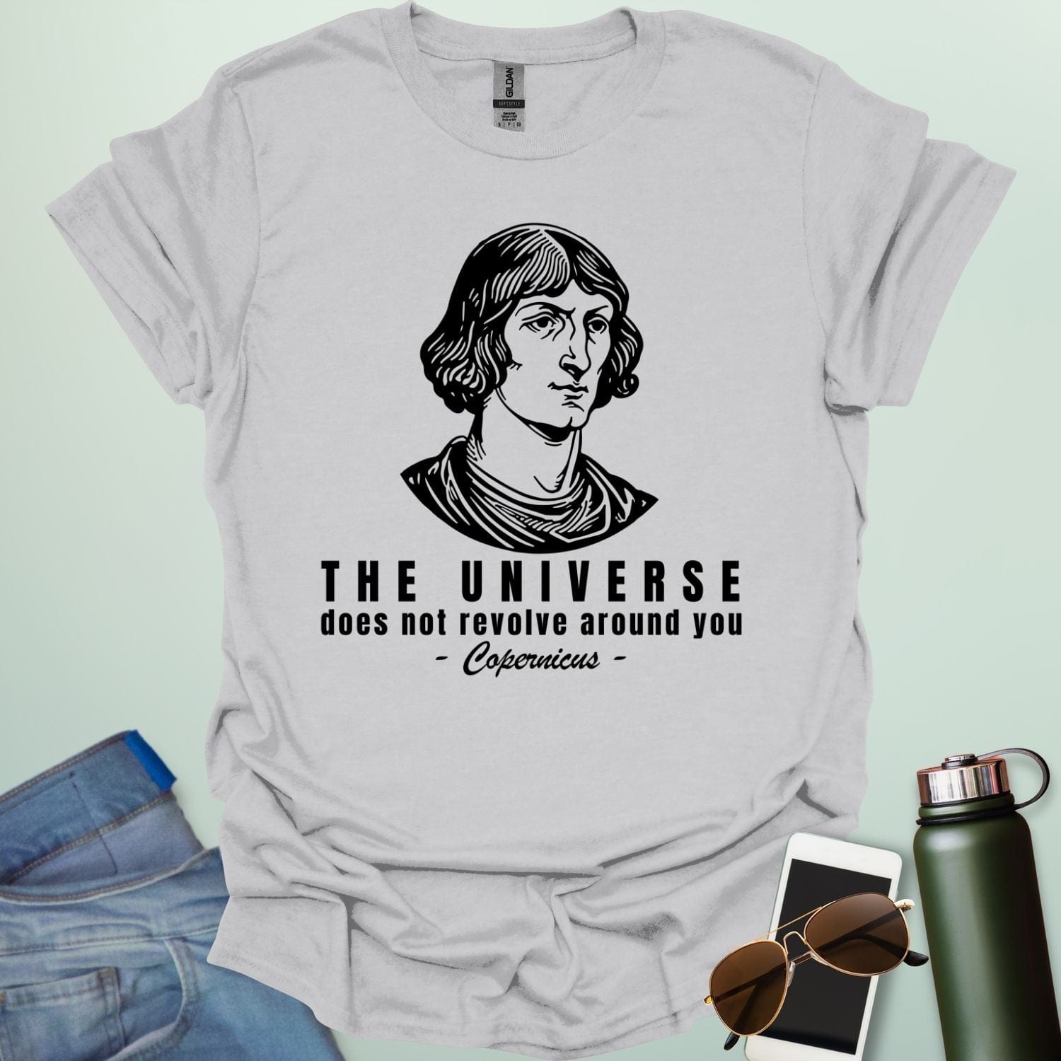 An ice grey shirt with a sketch of Copernicus with the text 'The Universe Does Not Revolve Around You' in a bold font.