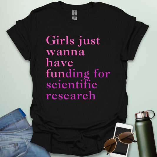 A black t-shirt with the text 'Girls just wanna have funding for scientific research' in a pink serif font.