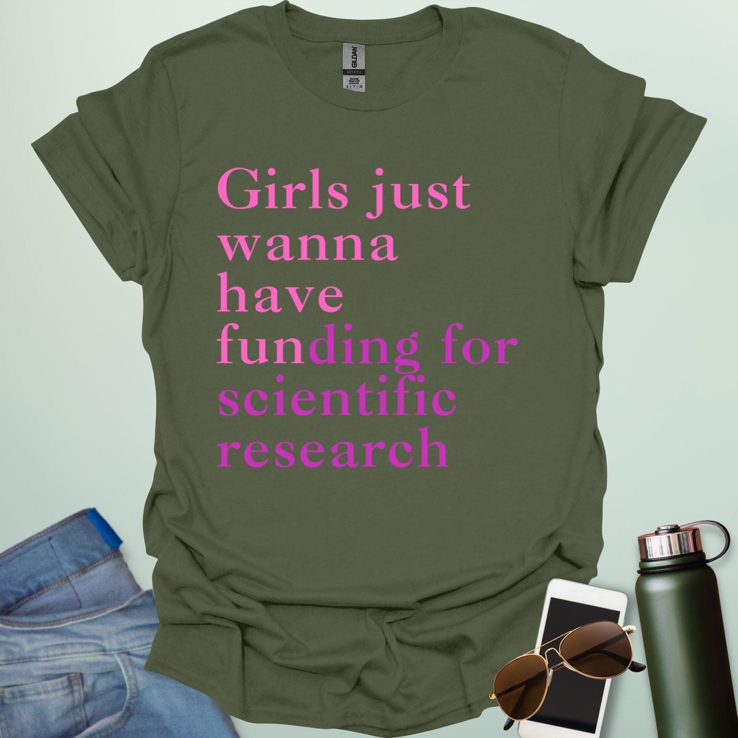 A military green t-shirt with the text 'Girls just wanna have funding for scientific research' in a pink serif font.