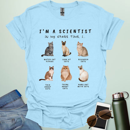 Light blue t-shirt with cat illustrations and text on a light gray background