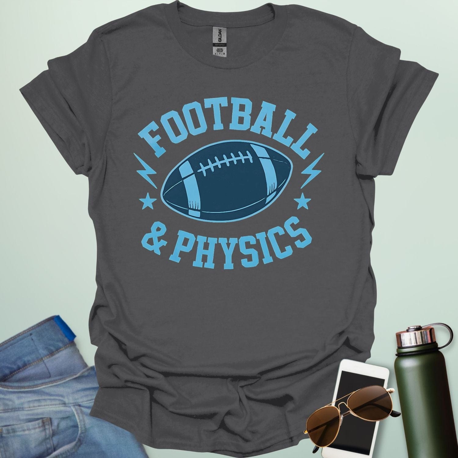 A charcoal grey t-shirt with a dynamic illustration of a football surrounded by lightning bolts and stars, with the text 'FOOTBALL & PHYSICS.'