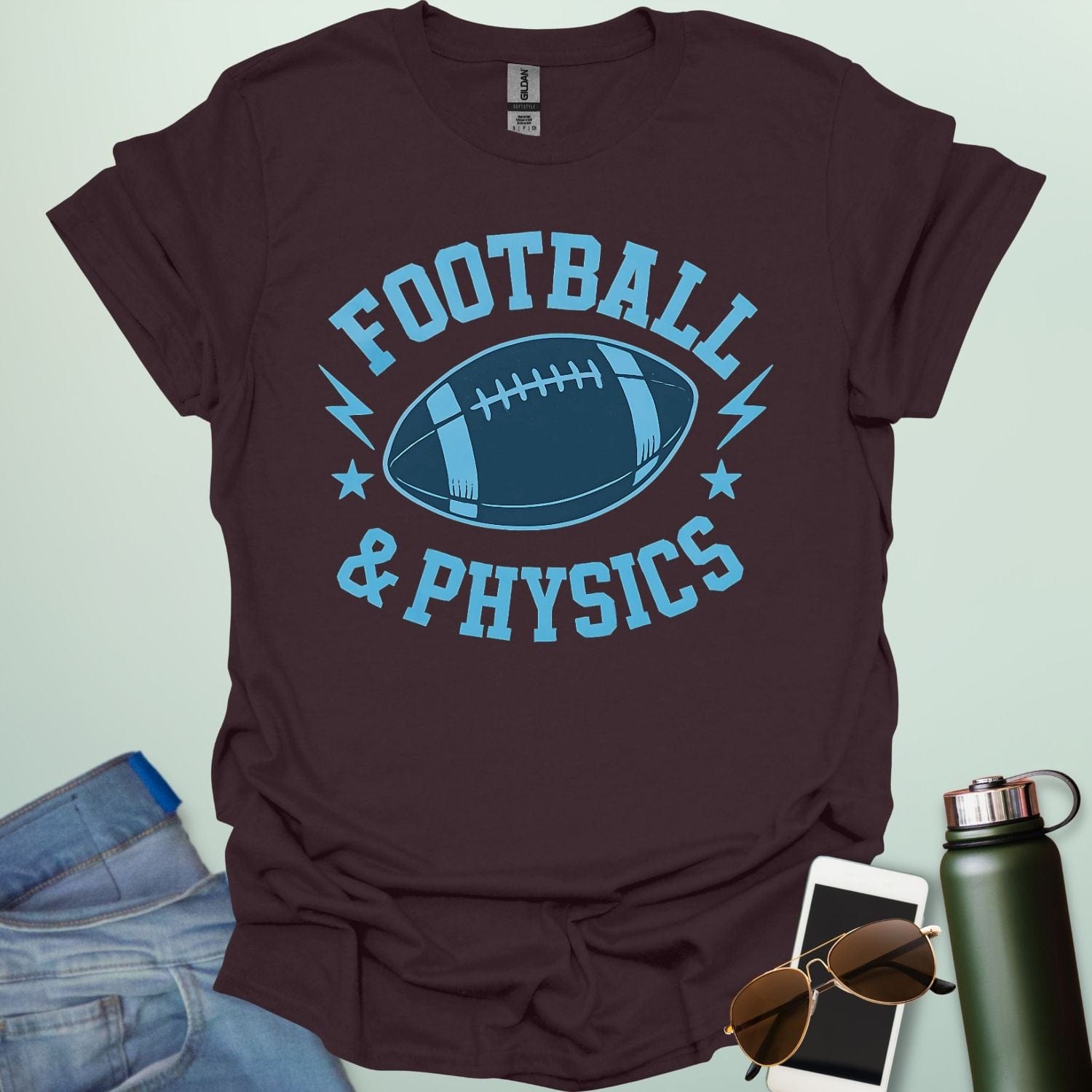 A dark chocolate t-shirt with a dynamic illustration of a football surrounded by lightning bolts and stars, with the text 'FOOTBALL & PHYSICS.'