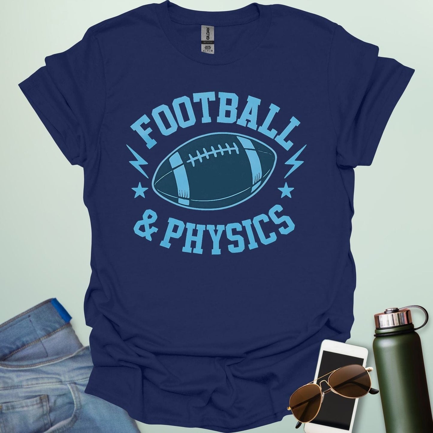 A navy blue t-shirt with a dynamic illustration of a football surrounded by lightning bolts and stars, with the text 'FOOTBALL & PHYSICS.'