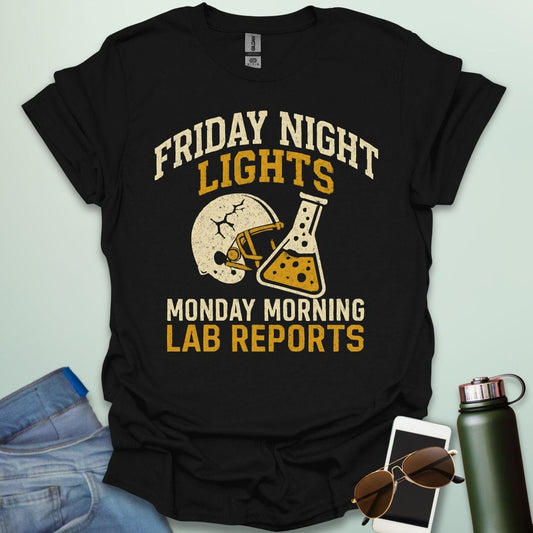 A black t-shirt with a vintage football helmet and a cracked lab flask, with the text 'FRIDAY NIGHT LIGHTS' and 'MONDAY MORNING LAB REPORTS.'
