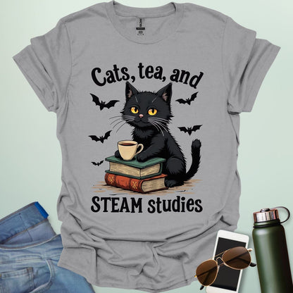 Cats, Tea, and STEAM Studies t-shirt with black cat, books, tea cup, and bats — a cozy geeky design for STEM/STEAM fans and book lovers.