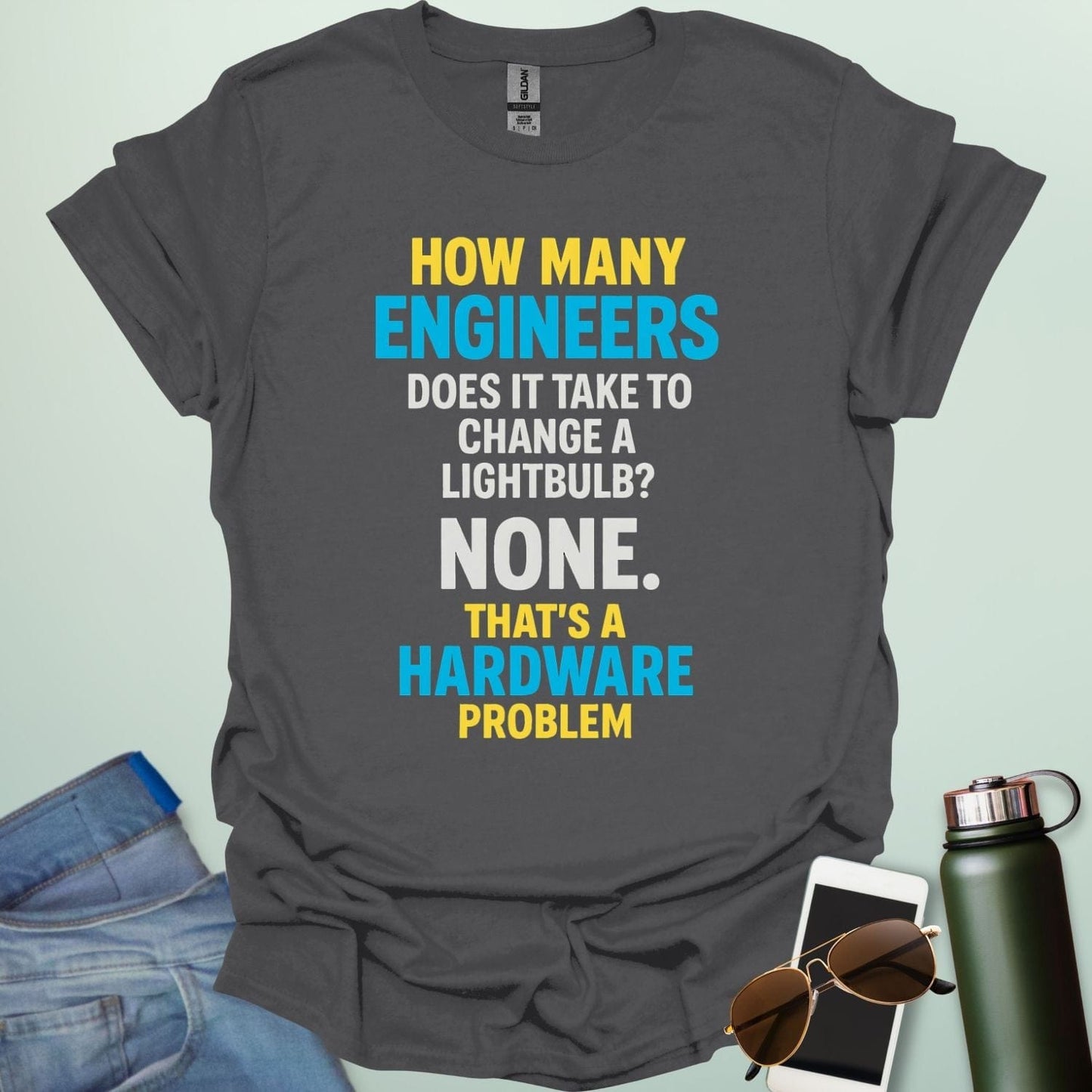 A charcoal grey t-shirt with the engineering joke: 'How many engineers does it take to change a lightbulb? NONE. That's a hardware problem.