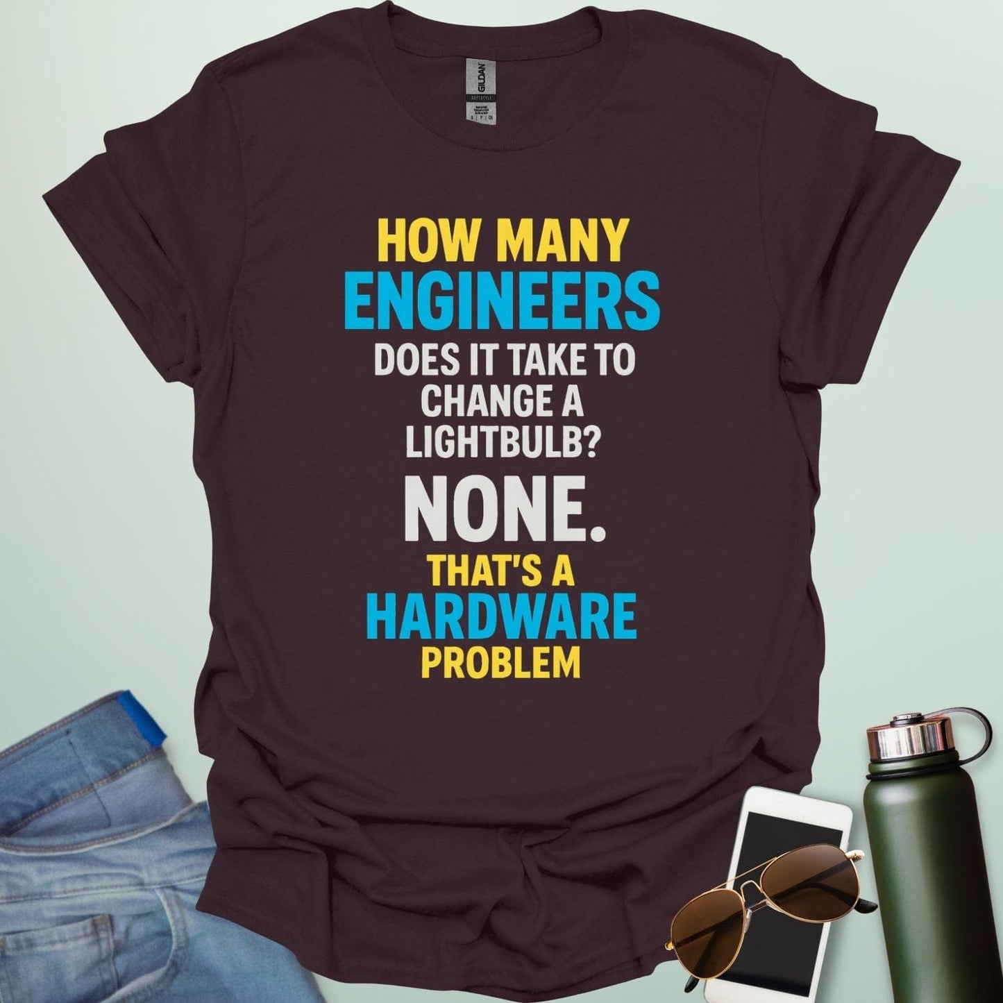 A dark chocolate t-shirt with the engineering joke: 'How many engineers does it take to change a lightbulb? NONE. That's a hardware problem.
