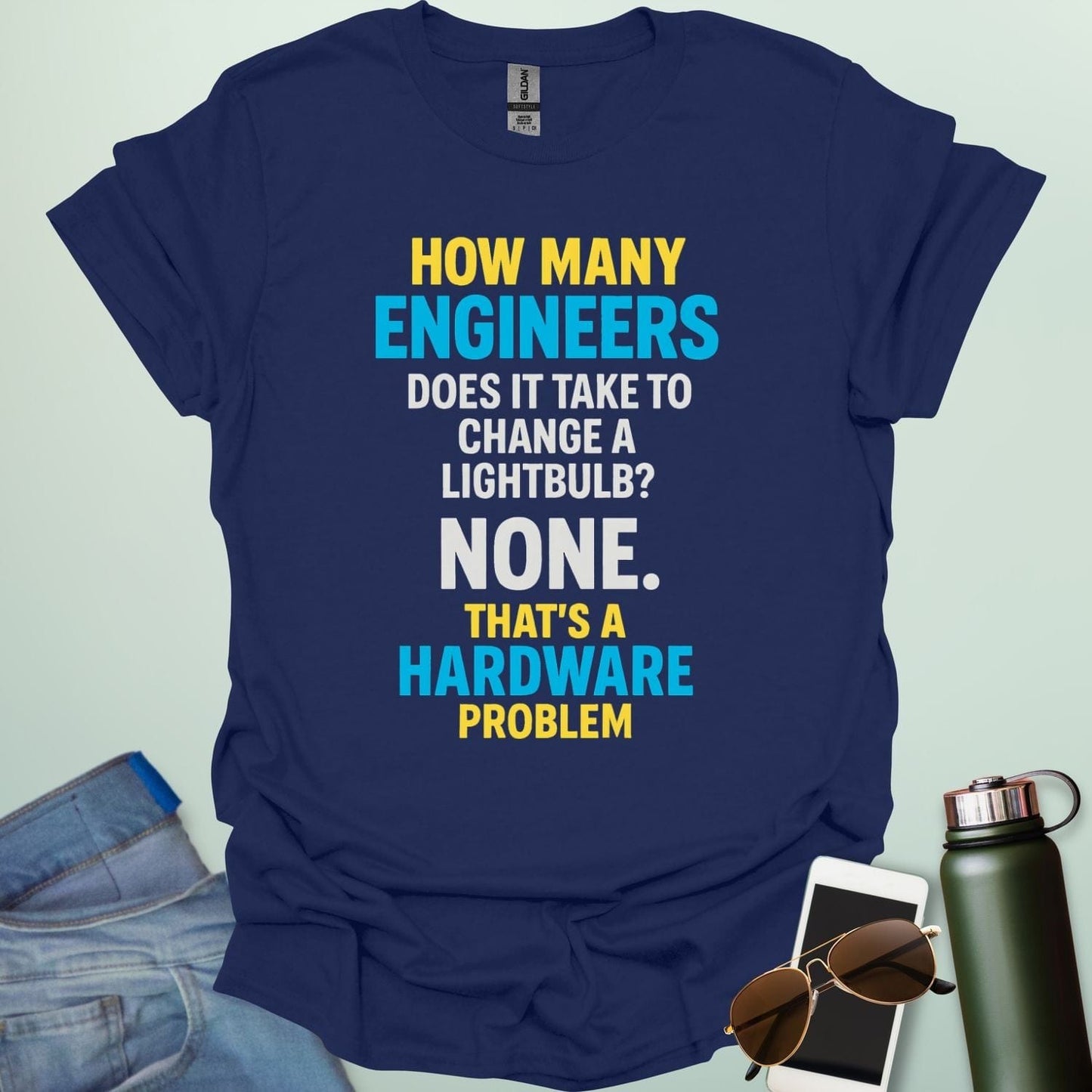 A navy blue t-shirt with the engineering joke: 'How many engineers does it take to change a lightbulb? NONE. That's a hardware problem.