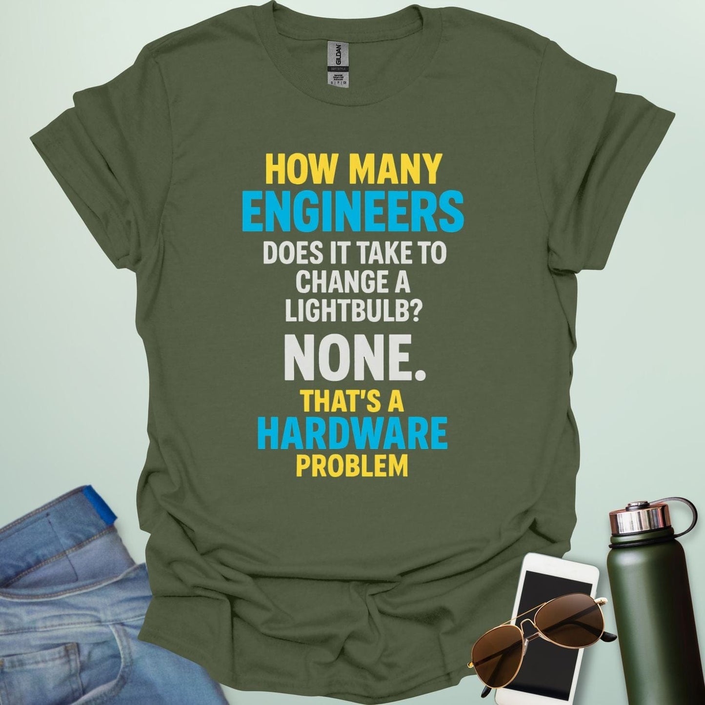 A military green t-shirt with the engineering joke: 'How many engineers does it take to change a lightbulb? NONE. That's a hardware problem.